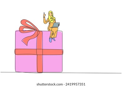 Continuous one line drawing of young Arabian businesswoman sitting on a giant gift box holding laptop computer. Reminding there is still a prize to be won. Business reward. Single line illustration