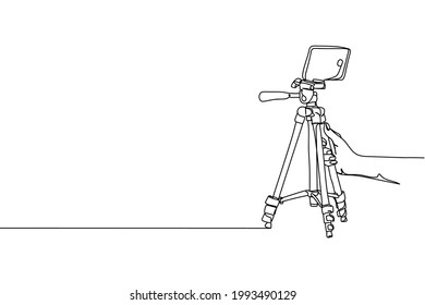 Continuous one line of smart mobile phone tripod in hand in silhouette on a white background. Linear stylized.Minimalist. Video concept