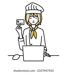 una cocinera que utiliza un ordenador portátil en su escritorio y sostiene una tarjeta de crédito