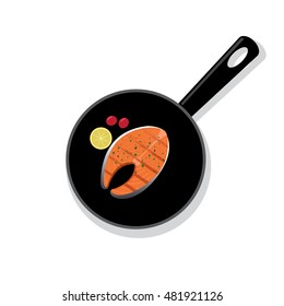 Cooked salmon steak on a black round iron pan