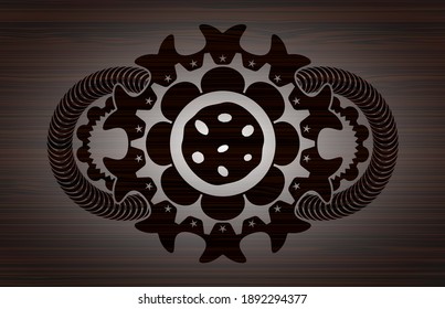 cookie icon inside realistic badge on fancy dark brown wood background Illustration. 