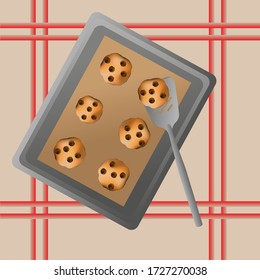 Cookies on a baking sheet with chocolate chips with a spatula on the table
