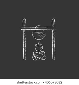 Cooking in cauldron on campfire. Drawn in chalk icon.