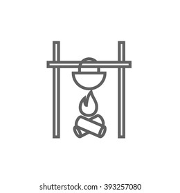 Cooking in cauldron on campfire line icon.