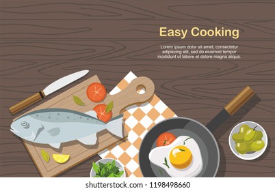 Cooking consept. Fried egg, Vegetables with spinach, Frying Pan and fish. Top view