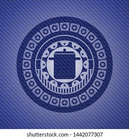 cooking pot icon inside badge with denim texture