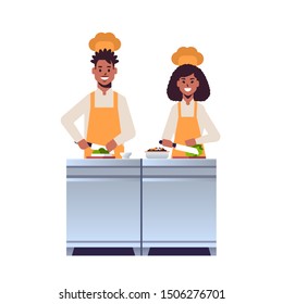 cooks couple professional chefs chopping fresh vegetables on carving board african american man woman restaurant workers in uniform preparing salad cooking food concept flat full length