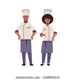 cooks couple professional chefs standing together african american man woman restaurant kitchen workers in uniform cooking food concept flat full length vector illustration