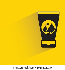 cosmetic bottle with label shadow on yellow background