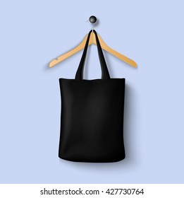 Cotton black textile bag holding with clothes hanger mockup