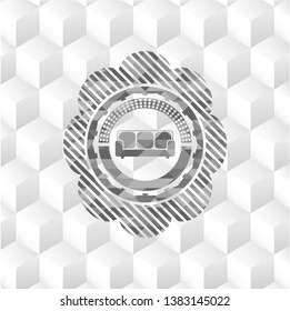 couch icon inside grey emblem with geometric cube white background