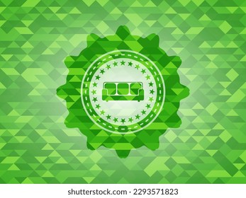 couch icon inside realistic green emblem. Mosaic background. 