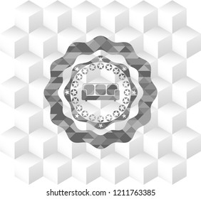 couch icon inside realistic grey emblem with geometric cube white background