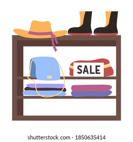 A counter with clothes and shoes. Selling different things. Sale in the store. Shopping exhibition. Hats bags and other accessories on the stand. Wooden showcase with items of clothing and footwear