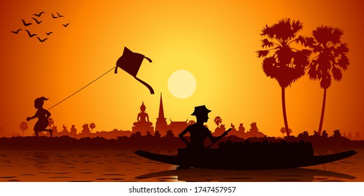 Country life of Asia boy playing with kite and man rows boat to go back home. Sunset time silhouette style