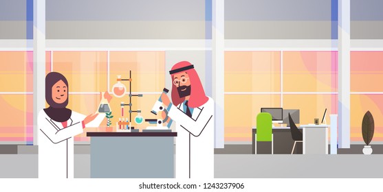 Couple Arabian scientists working with microscope laboratory doing research.  Arab man woman making scientific experiments doctors in lab interior portrait workplace horizontal