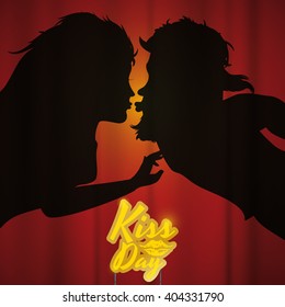 Couple behind backdrop silhouette smooching with a golden sign with a lips print for Kiss Day.