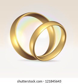 Couple of golden polished wedding rings over light background