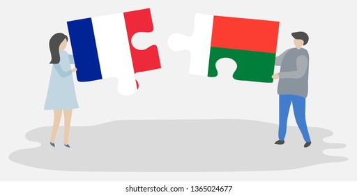 Couple holding two puzzles pieces with French and Malagasy flags. France and Madagascar national symbols together.