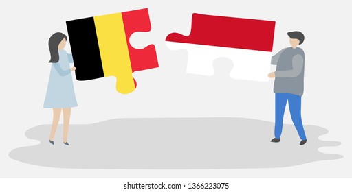 Couple holding two puzzles pieces with Belgian and Indonesian flags. Belgium and Indonesia national symbols together.