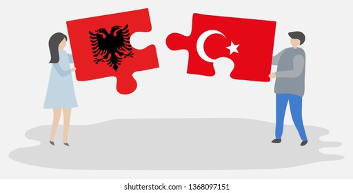 Couple holding two puzzles pieces with Albanian and Turkish flags. Albania and Turkey national symbols together.