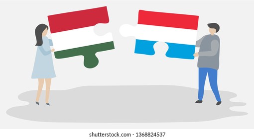 Couple holding two puzzles pieces with Hungarian and Luxembourgish flags. Hungary and Luxembourg national symbols together.