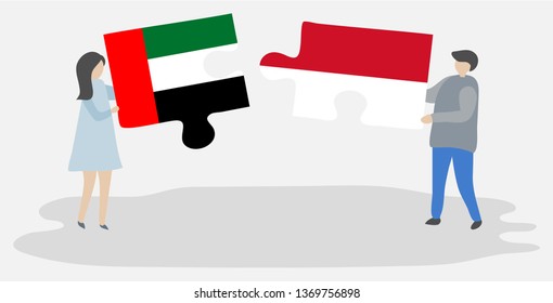 Couple holding two puzzles pieces with Emirian and Indonesian flags. United Arab Emirates and Indonesia national symbols together.