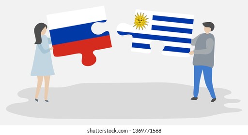 Couple holding two puzzles pieces with Russian and Uruguayan flags. Russia and Uruguay national symbols together.