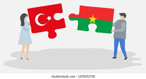 Couple holding two puzzles pieces with Turkish and Burkinabe flags. Turkey and Burkina Faso national symbols together.