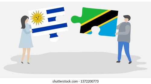 Couple holding two puzzles pieces with Uruguayan and Tanzanian flags. Uruguay and Tanzania national symbols together.