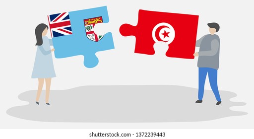 Couple holding two puzzles pieces with Fijian and Tunisian flags. Fiji and Tunisia national symbols together.