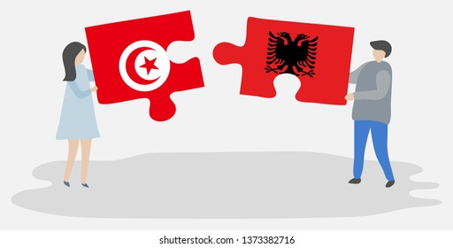 Couple holding two puzzles pieces with Tunisian and Albanian flags. Tunisia and Albania national symbols together.