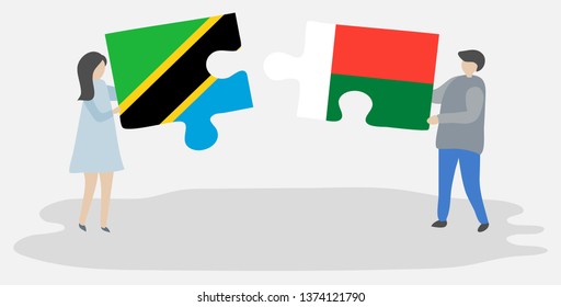 Couple holding two puzzles pieces with Tanzanian and Malagasy flags. Tanzania and Madagascar national symbols together.
