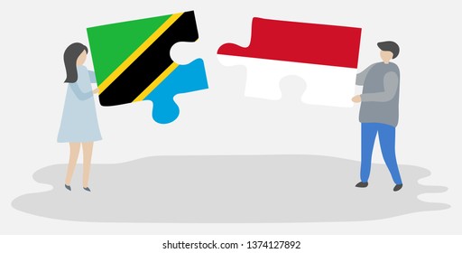 Couple holding two puzzles pieces with Tanzanian and Indonesian flags. Tanzania and Indonesia national symbols together.