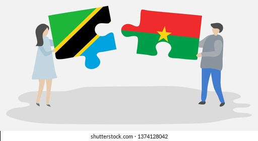 Couple holding two puzzles pieces with Tanzanian and Burkinabe flags. Tanzania and Burkina Faso national symbols together.