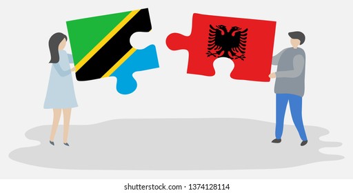 Couple holding two puzzles pieces with Tanzanian and Albanian flags. Tanzania and Albania national symbols together.
