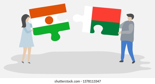 Couple holding two puzzles pieces with Nigerien and Malagasy flags. Niger and Madagascar national symbols together.