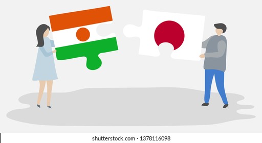Couple holding two puzzles pieces with Nigerien and Japanese flags. Niger and Japan national symbols together.