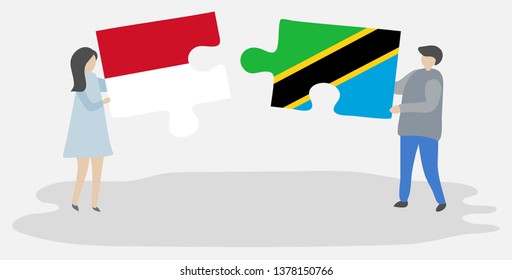 Couple holding two puzzles pieces with Monegasque and Tanzanian flags. Monaco and Tanzania national symbols together.