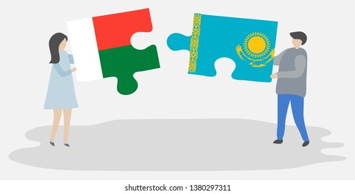 Couple holding two puzzles pieces with Malagasy and Kazakh flags. Madagascar and Kazakhstan national symbols together.