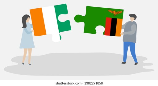 Couple holding two puzzles pieces with Ivorian and Zambian flags. Ivory Coast and Zambia national symbols together.