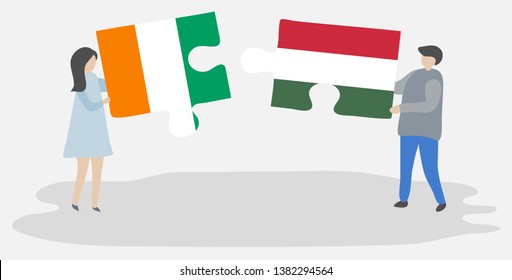 Couple holding two puzzles pieces with Ivorian and Hungarian flags. Ivory Coast and Hungary national symbols together.