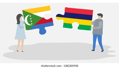 Couple holding two puzzles pieces with Comoran and Mauritian flags. Comoros and Mauritius national symbols together.