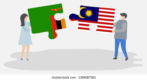 Couple holding two puzzles pieces with Zambian and Malaysian flags. Zambia and Malaysia national symbols together.