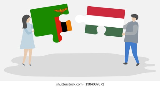 Couple holding two puzzles pieces with Zambian and Hungarian flags. Zambia and Hungary national symbols together.