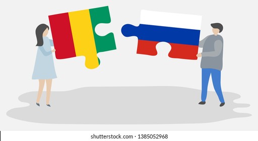 Couple holding two puzzles pieces with Guinean and Russian flags. Guinea and Russia national symbols together.