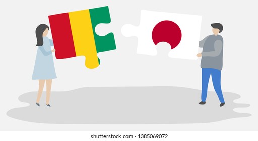 Couple holding two puzzles pieces with Guinean and Japanese flags. Guinea and Japan national symbols together.