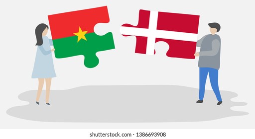 Couple holding two puzzles pieces with Burkinabe and Danish flags. Burkina Faso and Denmark national symbols together.