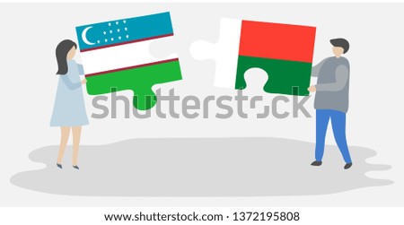 Couple holding two puzzles pieces with Uzbek and Malagasy flags. Uzbekistan and Madagascar national symbols together.