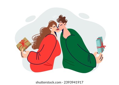 Couple in love kissing after exchanging christmas gifts on new year eve or valentine day. Romantic young man and woman celebrating anniversary and enjoying gifts from significant other.